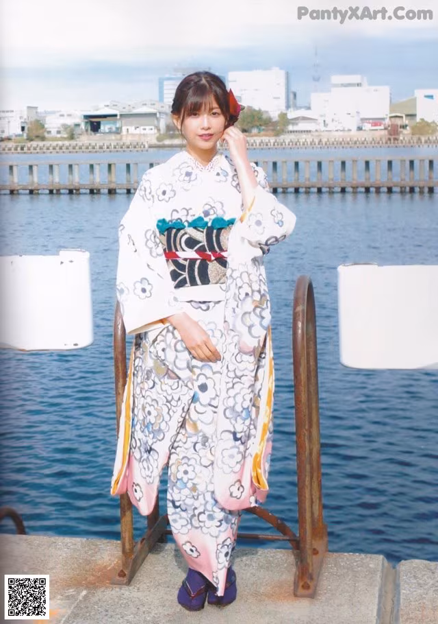 A woman in a kimono standing by the water.