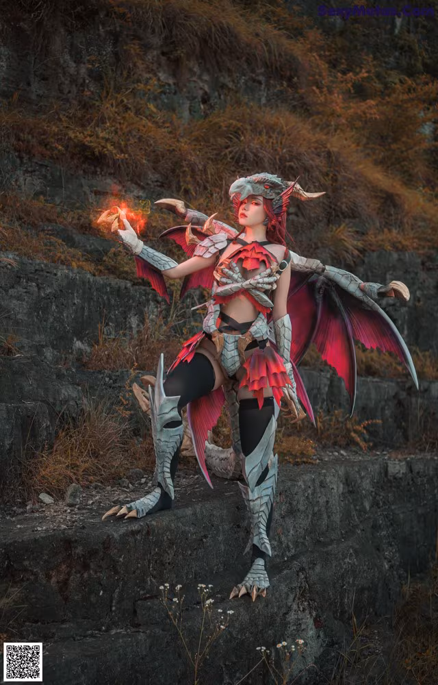 A woman dressed as a dragon holding a fire in her hand.
