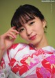 A woman in a pink and white kimono posing for a picture.