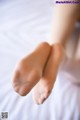 A close up of a person's bare feet on a bed.