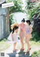 A group of young women standing next to each other on a dirt road.