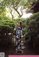A woman in a kimono standing in a garden.