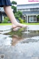 A woman's feet in a puddle of water.