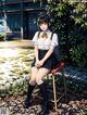 A girl sitting on a chair in front of a building.